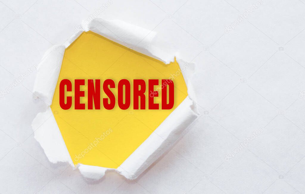 Top view of white torn paper and the text CENSORED on a yellow background.