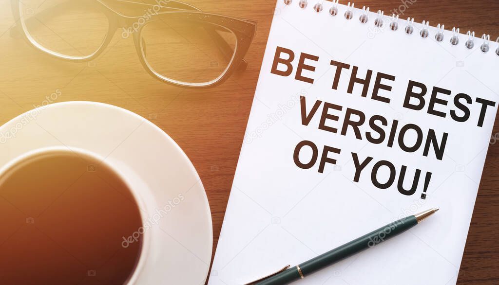 Be the best version of you, the text is written in a notebook with a cup of coffee and glasses on a wooden background.