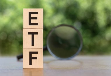 ETF - Ahşap küplerle ilgili, arka planda büyüteçle değiş tokuş Fonu metni