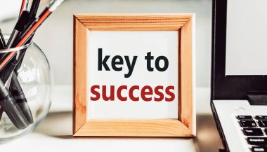 Ofis masasında ahşap çerçeveli SUCCESS metni için anahtar.