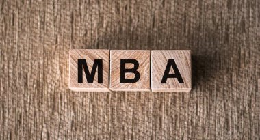 Kahverengi arka planda tahta bloklara yazılmış MBA sözcüğü.