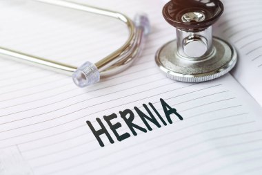 Hernia. Kalem steteskopunun yanındaki tıbbi kartta yazı var..