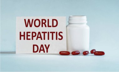 Açık mavi bir arkaplanda beyaz şişe haplarının yanında DÜNYA HEPATİTİS Günü yazılı bir kart var..