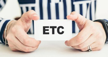 ETC. Üzerinde mesaj yazılı bir kart tutan kadın..
