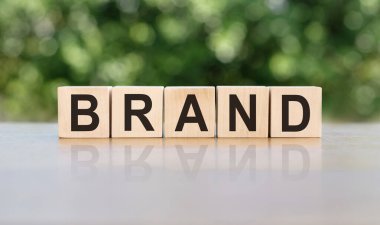 Tahta bloklara yazılmış bir marka. Metin siyah harflerle yazılır ve masanın ayna yüzeyine yansıtılır. Tasarımınız için iş kavramı.