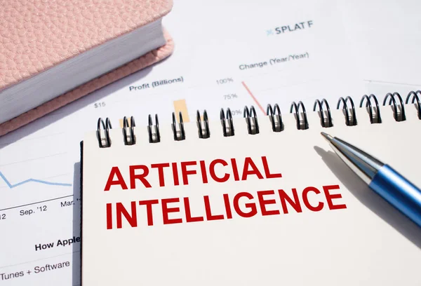 ARTIFICIAL INTELLIGENCE text written on notepad with pen on financial documents.