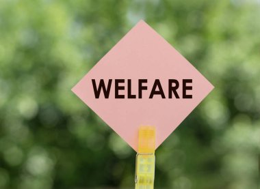 Yeşil arkaplanda pembe not kağıdına WELFARE kelimesi.