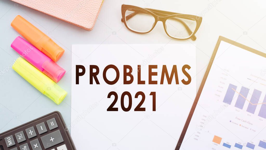 PROBLEMS 2021 text on office desk with calculator, markers, glasses and financial charts.