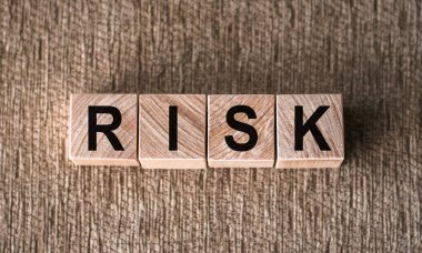 RISK. Kahverengi arka planda tahta bloklara yazılmış bir sözcük.