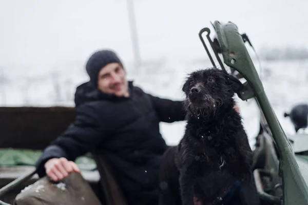 ミンスク ベラルーシ 2021年1月9日 冬の森の中でヴィンテージカーで犬と一緒に運転する若い男 — ストック写真