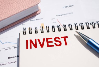 Not defterine yazılmış INVEST metni, mali belgelerde kalemle.