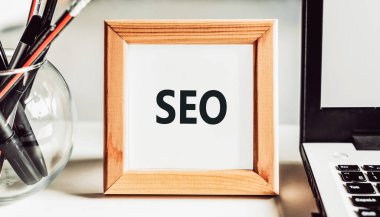SEO - arama motoru optimizasyonu. Ofis masasında ahşap çerçeveli metin.