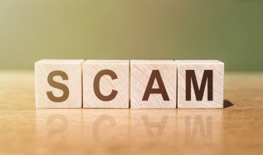 Tahta masadaki tahta bloklara SCAM kelimesi yazılmış. Tasarımınız için kavram.