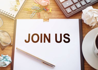 Tahta bir masanın üzerinde bize katılan bir ofis kağıdı var. Hesap makinesi, bardak, kalem, buruşuk kağıt ve bir fincan kahve ile iş yeri.