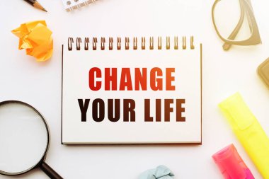 Ofis araçlarıyla beyaz masadaki not defterinde hayatınızı değiştirin.