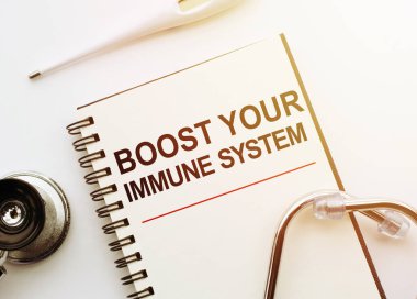 Tıbbi konsept. Sözcüklü defter İMMUNE Sisteminizi stetoskop ve termometreyle birlikte beyaz masaya bırakın..