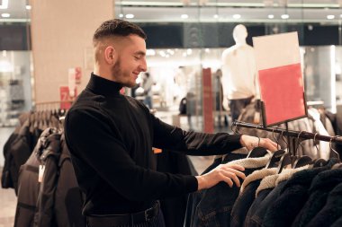 Mağazada kıyafet seçen bir gencin portresi.