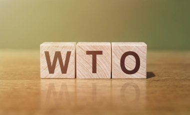 WTO - World Trade Organization acronym written on wooden blocks on wooden table. Concept for your design. clipart