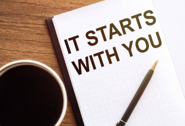 Seninle başlar. Tahta masadaki not defterine yazarsın..