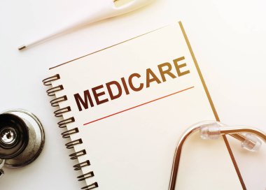 Steteskop ve kalemle dolu bir masanın üzerinde yazılı metni olan defter sayfası, tıbbi konsept..