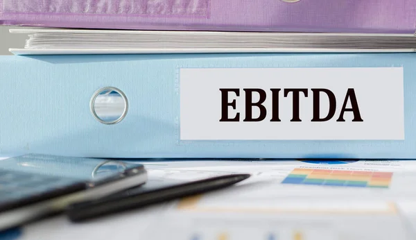 Belgeler ve hesap makinesiyle dizine yazılmış EBITDA metni.