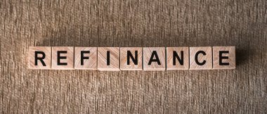 Kahverengi arka planda tahta bloklara yazılmış REFINANCE sözcüğü.