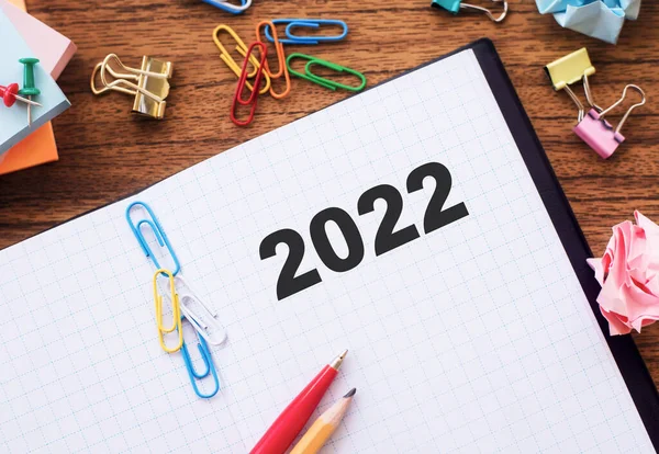 2022, ofis masasındaki bir defterde yazılıdır. İş ve finans kavramı.