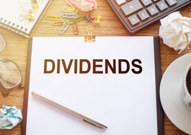 Ahşap bir masanın üzerinde ofis kâğıdı var. Üzerinde de 