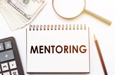 MENTORING - Ofis arkaplanlı bir defter üzerine yazılmış metin.