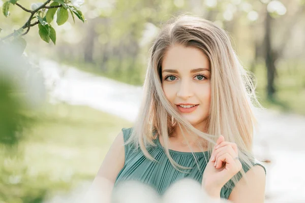 Çiçekli Bahar Bahçesinde Uzun Sarı Saçlı Güzel Bir Kız Gülümse — Stok fotoğraf