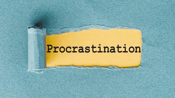 PROCRASTINATION - yırtık ve yırtık kağıt altında yazılmış kelimeler.