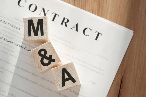 Sözcük M & A (Birleştirme ve Satın Alma) kontrat belgelerindeki tahta küplere.