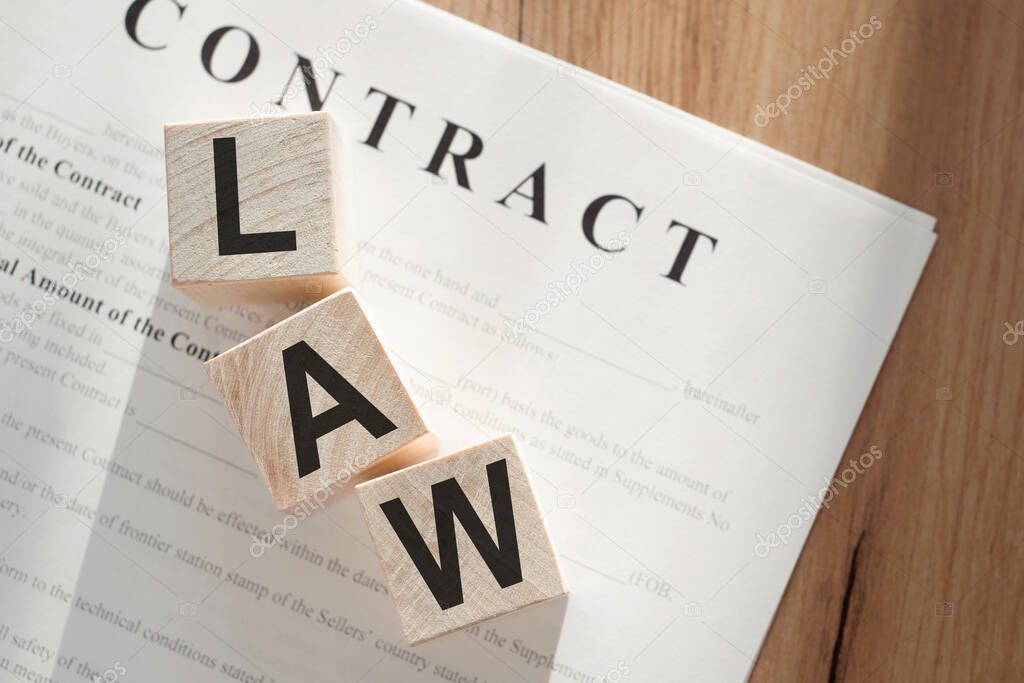 Word LAW on wooden cubes on contract documents background