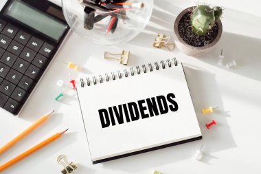 Beyaz ofis arka planında bölünmüş yazılar içeren not defteri.