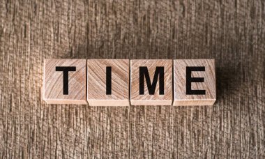 TIME - kahverengi arkaplanda tahta bloklara yazılmış sözcük.
