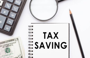 Hesap makinesi, dolar ve büyüteçle birlikte vergilendirilmiş not defteri..