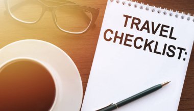 TRAVEL CHECKLIST - Kağıt üzerinde bir fincan kahve ve tahta arka planda cam bardakla sinemalarda metin.