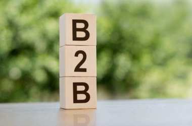 The word B2B - busines to business, built from wooden cubes outdoors on the background of nature.