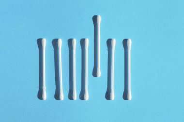 Q-tip lies out from the crowd of other on a white background