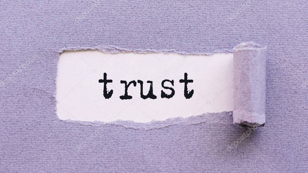 The text TRUST appears on torn lilac paper against a white background.