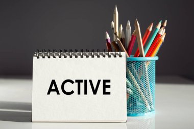 ACTIVE - renkli kalemli bir deftere yazılan yazı.