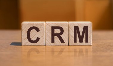 CRM - Müşteri İlişkileri Pazarlama, Turuncu duvar arka planında tahta küplerle ilgili yazı.