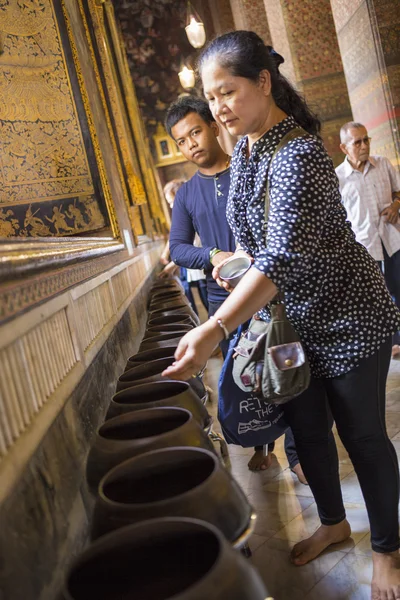 Donner l'aumône à la statue de Bouddha endormi dans le temple de Wat Pho — Photo