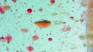 Yakın çekim kırmızı mürekkep kabarcıkları suda hareket
