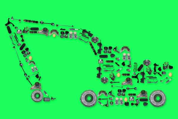 Many new spare parts in the form of excavator isolated on green background — Stock Photo, Image
