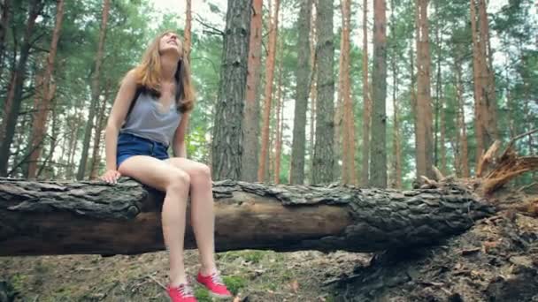 Frau sitzt mit baumelnden Beinen — Stockvideo