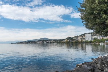 Göl kıyısında dağlarla çevrili binalar var. Montreux, İsviçre 'de Cenevre Gölü