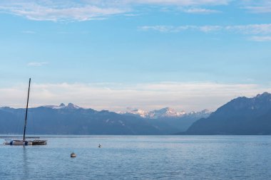 Alp Gölü 'nün sakin mavi suları ve karlı tepelerle çevrili bir teknesi var. Cenevre Gölü 'ndeki Montreux