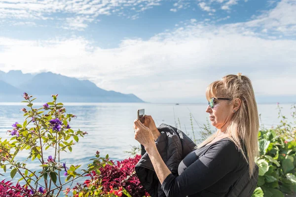 Mujer Rubia Tomando Una Foto Lago Alpino Rodeado Flores Con — Foto de Stock