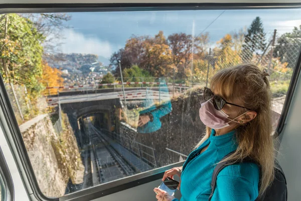 Mulher Loira Máscara Facial Segurando Seu Telefone Viajando Funicular — Fotografia de Stock